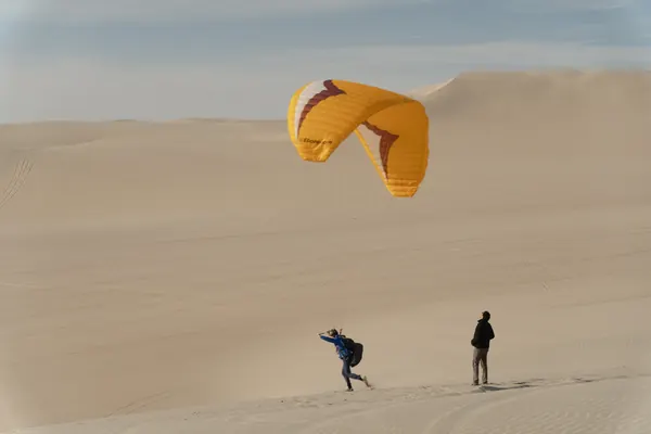 Práctica de parapente con instructor en el desierto