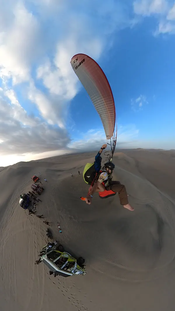 Pasajero disfrutando del vuelo en parapente en Huacachina