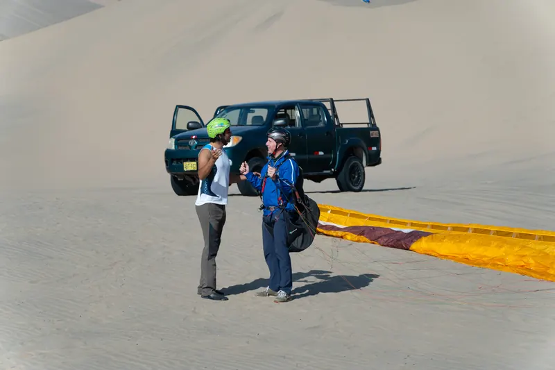 Preparación del vuelo en parapente junto al buggy en Huacachina
